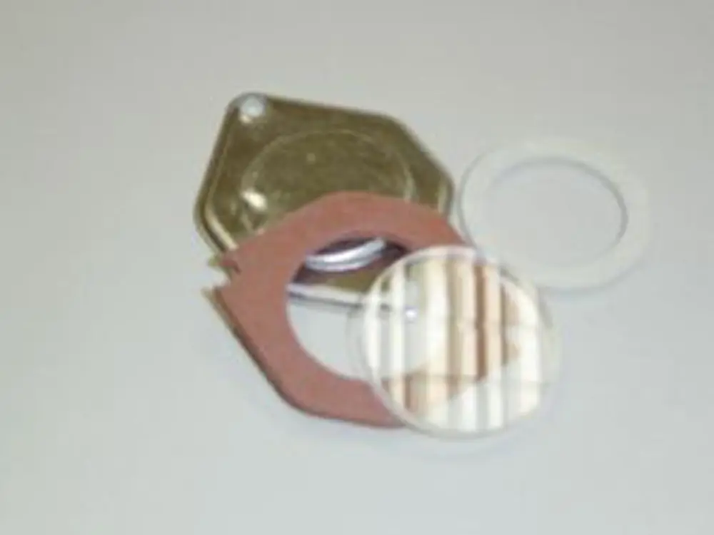 Remeha Schauglas-Set bestehend aus einer runden Glaslinse, einer Dichtung und einer Metallabdeckung, auf hellem Hintergrund angeordnet.